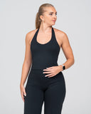 Woman wearing a black athletic outfit on a gray background