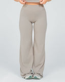 Person wearing beige high-waisted pants on a light gray background