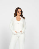 Woman wearing a white outfit on a plain background