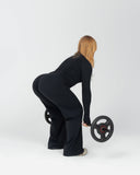 Person in a black outfit lifting a barbell on a white background