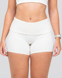 Person wearing white high-waisted shorts on a plain background
