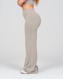 Person wearing beige wide-leg pants and a matching top on a white background