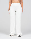 Person wearing white wide-leg pants on a plain background