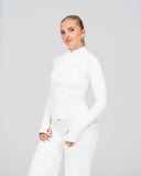 Woman wearing a white outfit on a plain background