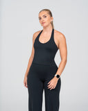 Woman wearing a black athletic outfit on a gray background