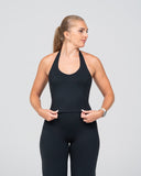 Woman wearing a black athletic outfit on a gray background