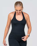 Woman wearing a black athletic outfit on a light gray background