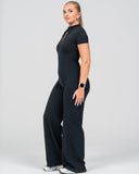 Woman wearing a black jumpsuit on a white background