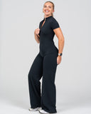 Woman wearing a black jumpsuit on a white background