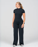 Woman wearing a black bodysuit on a white background