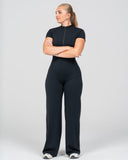 Woman wearing a black jumpsuit on a white background
